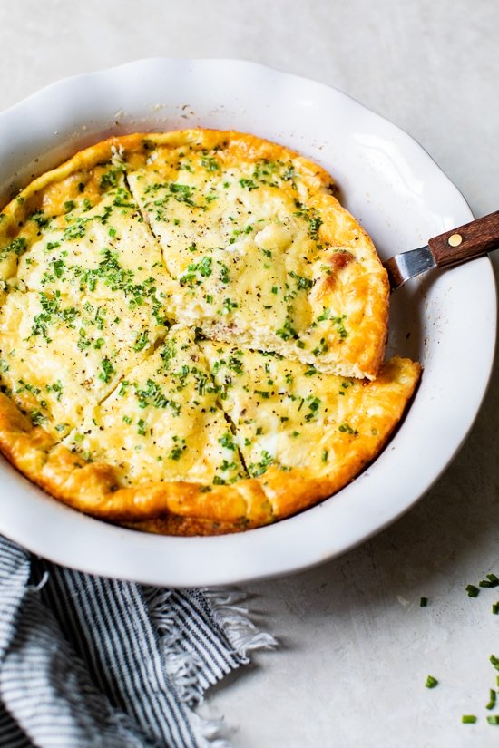 Crustless Quiche Lorraine in a pie dish with a spatula.