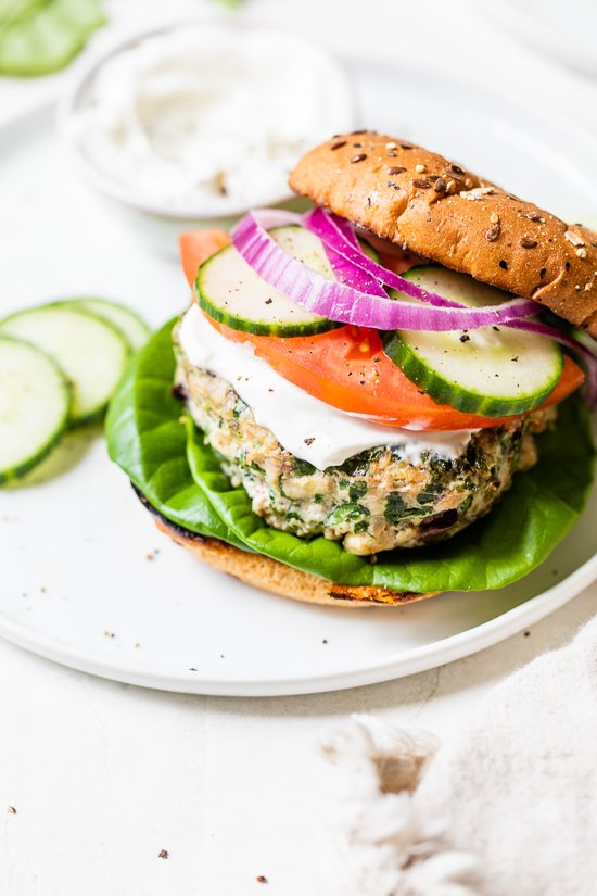 Greek turkey burger with bun, tomatoes, cucumber on a plate