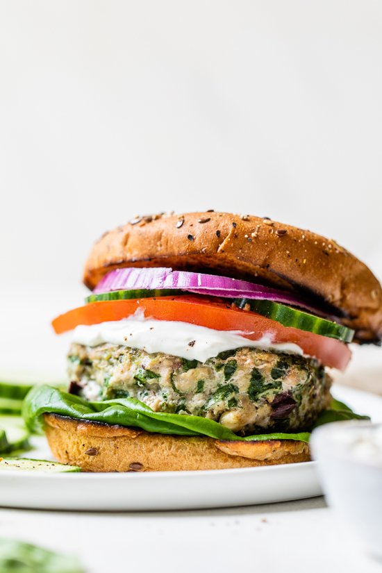 Greek turkey burger with bun, tomatoes, cucumber on a plate