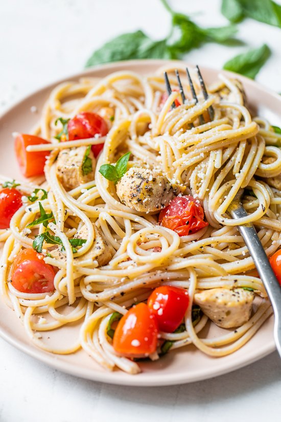 Spaghetti with Sauteed Chicken and Grape Tomatoes on a plate with a fork.