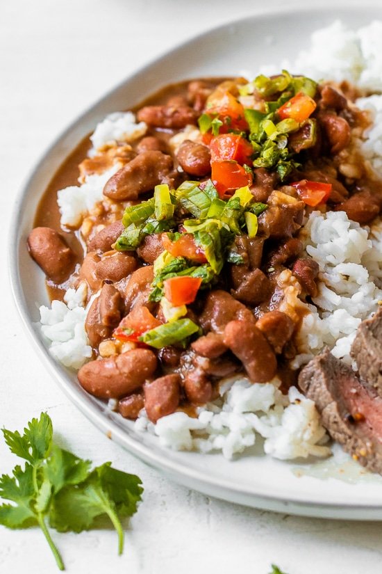 Dominican Beans over rice with aji picante on top and steak on the side.