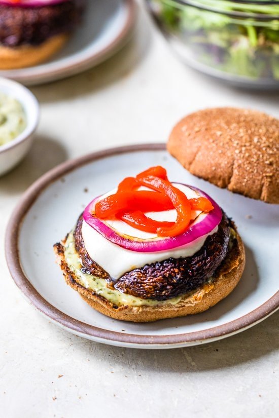 These grilled Portobello Mushroom Burgers topped with mozzarella, red peppers, and pesto mayo, are delicious and an excellent vegetarian burger option.